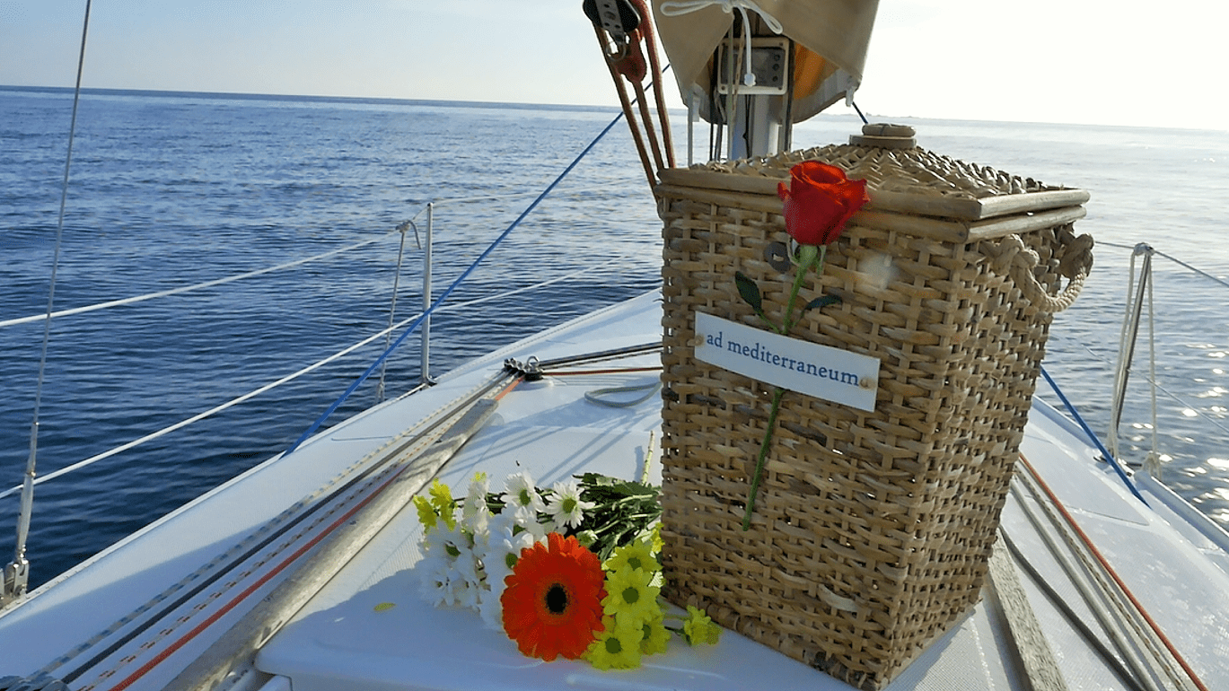 Seebestattung im Mittelmeer mit Urnenkorb und schönen Blumen